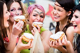 Girls at German Fasching Carnival eating doughnut-like traditional pastry