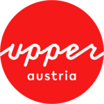 Logo Upper Austria Tourism: red circle with white upperaustria lettering